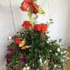 Mixed potted flowers in a metal container with a large ribbon bow