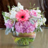 Pink gerbera daisy and hydrangea bouquet in a striped glass vase