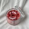 Pink candle in a clear glass jar with a lid and 