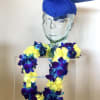 Graduation display with a blue cap and a lei of yellow and purple flowers