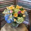 Lush rounded bouquet of yellow garden roses, blue &amp; green hydrangeas, peonies