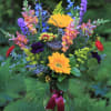 Mixed bouquet in a glass vase with bright yellow and purple flowers