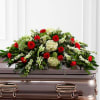 Red roses and white flowers arranged on a casket