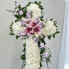 White floral cross with pink lilies and lavender roses on an easel