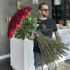Large bouquet of red roses held by a man in sunglasses