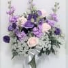 Lavender and pale pink bouquet in a glass vase with a silver ribbon