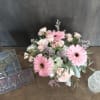 Pink gerbera daisies and pale roses arranged on a table