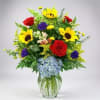 Bright yellow sunflowers steal the show in this joyful flower arrangement, paired