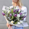 Bouquet of purple and white tulips with eucalyptus in paper wrap
