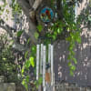 Wind chime hanging from a tree branch with stained-glass accents