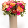 Soft, pink, and golden blooms arranged with fresh greenery for a bright