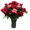 Bouquet of red roses and pink carnations in a dark glass vase