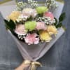 Soft pastel carnations with white filler, wrapped in paper and satin ribbon