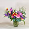 A joyful blend of pinks, sunny yellows, and rich purples, this arrangement