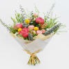Bouquet of pink peonies and yellow billy balls wrapped in white paper