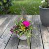 Bright hot-pink chrysanthemums and jewel-toned purple calla lilies create an immediate sunny