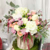 Bouquet of white and blush flowers in a wooden container