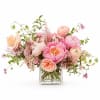 A soft, whimsical garden-style arrangement featuring lush peonies in blush and pink
