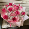 Bouquet of hot pink roses with white baby's breath in pink wrapping