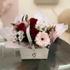 Bouquet of red roses, pink gerbera daisies, and white daisies in a gift box