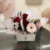 Bouquet of red roses, pink gerbera daisies, and white daisies in a gift box