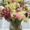 Mixed pink, cream, and burgundy flowers in a glass vase