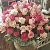 Large bouquet of pink and cream roses in a clear vase
