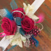 Handheld bouquet of hot pink roses and white lilies with colorful decorative feathers