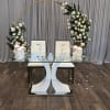 White rose arch over a glass table with candles and 