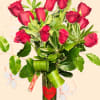 Bouquet of red roses in a glass vase with a heart tag