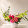 A joyful, garden-style arrangement in vibrant pinks, soft white, and fresh spring