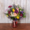 Bright yellow tulips and soft pink roses take center stage in this