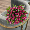 Bouquet of bright pink tulip buds with green leaves