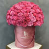 Large pink rose arrangement in a round velvet hatbox