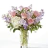 Pink roses and lavender flowers in a clear glass vase