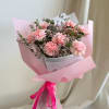 Pink carnation bouquet wrapped in pastel paper with a ribbon
