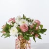 Pink roses and white daisies in a pink glass vase