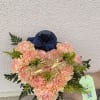 Peach and pink carnations clustered around soft blush roses create a cheerful