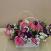 A bright decorative like pocketbook full of flowers, this floral arrangement is