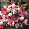 Pink lilies, roses, and carnations in a wicker basket