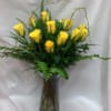 Premium yellow roses arranged in a clear glass vase with leather leaf