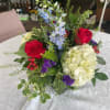 A beautiful mix of roses, delphinium, hydrangea, statice, andhypericum berries. This arrangement