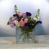 Soft pink roses and lavender chrysanthemums lead this mixed-color flower arrangement, a