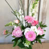 Pink and white flowers arranged in a glass vase