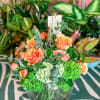 Peach roses and green hydrangeas in a clear glass vase