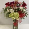 Mixed bouquet in a clear glass vase with red roses and white daisies