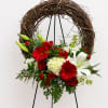 This is a floral arrangement designed on a circular grapevine wreath mounted