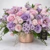 A soft cascade of pink and lavender roses accented with delicate orchids