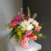 This beautiful flower arrangement of fresh mixed seasonal blooms is made by