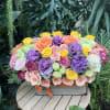 Mixed bouquet of roses and purple ornamental blooms in a wooden box